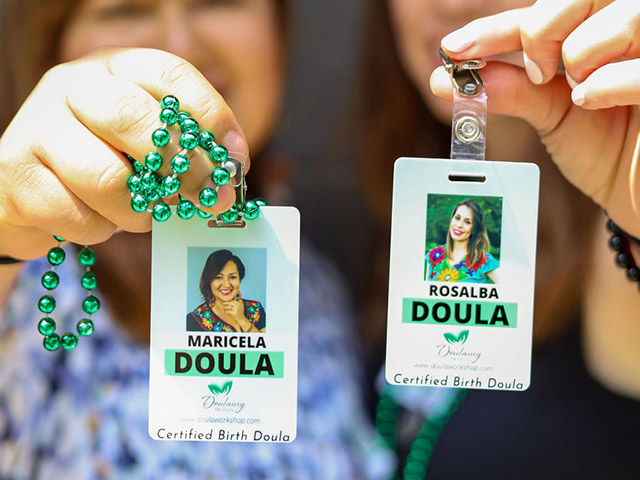 Doula's holding their certified doula badges